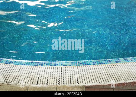 Un pas à l'entrée de la piscine en fibre de verre avec de l'eau bleue propre et rafraîchissante dans le spa du complexe. Parquet blanc en teck ou en mélèze. Photo de haute qualité Banque D'Images