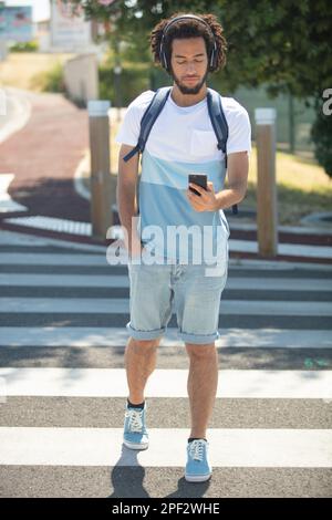 un sympathique gars qui marche sur un passage pour piétons ou sur un passage à côté Banque D'Images