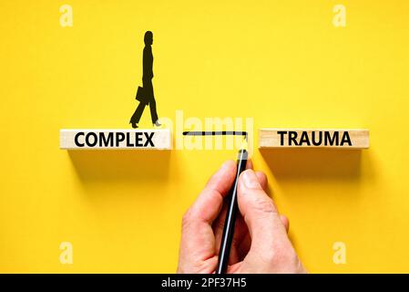 Symbole de traumatisme complexe. Concept mots trauma complexe sur bloc de bois. Beau tableau noir fond noir. Psychologie des affaires complexe traumatisme concep Banque D'Images