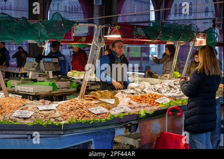 Venise, Italie- 23 février 2023: Les gens magasinent pour du poisson au marché aux poissons du Rialto à Venise, Italie Banque D'Images