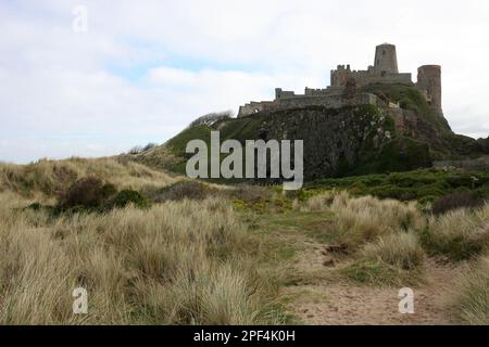 Plage de Bamburgh sous le château, l'imposant château médiéval et situé dans la région de la côte de Northumberland d'une beauté exceptionnelle Banque D'Images