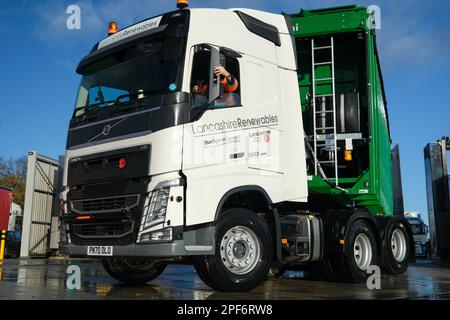 Camion Volvo tirant une remorque de recyclage à benne basculante en vrac sort d'un lavage de camion Banque D'Images