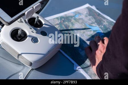 Madrid, Espagne. 03 03 2023: Commande radio d'un drone pro fantôme 4, une photo aérienne imprimée et une main d'homme. Banque D'Images