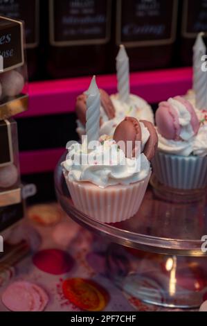 Assortiment de pâtisseries sucrées fraîches françaises, petits gâteaux roses avec bougies en vitrine dans la confiserie, traduction anglaise : biscuits aux noix de rose Banque D'Images