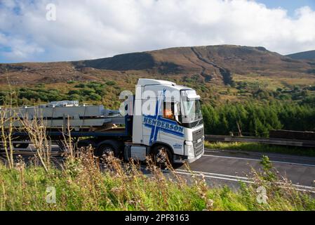 Camion Volvo tirant une remorque à plateau le long de la passe Woodhead A628 avec Wildboar Clough en arrière-plan Banque D'Images