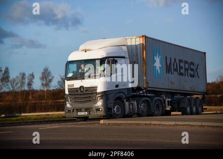 Un camion Mercedes-Benz Actros tirant une remorque avec un conteneur d'expédition Maersk, traverse un rond-point devant iport près de Doncaster Banque D'Images