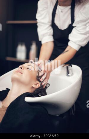 Celui qui a dit que l'argent ne peut pas acheter le bonheur n'a pas trouvé le bon coiffeur. une belle jeune femme se laver les cheveux au salon. Banque D'Images