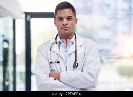 Portrait, homme et médecin avec les bras croisés, focalisé et confiant dans l'hôpital, la clinique et la chirurgie. Professionnel de santé sérieux, fier et jeune en blouse de laboratoire Banque D'Images