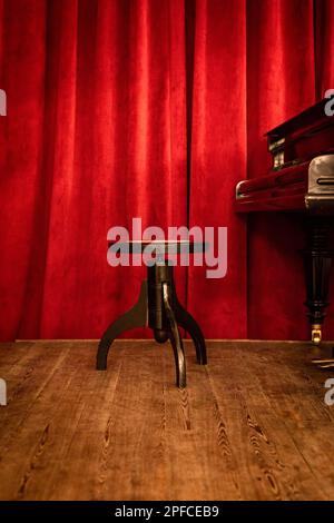 Un banc de piano sur scène en rouge Banque D'Images