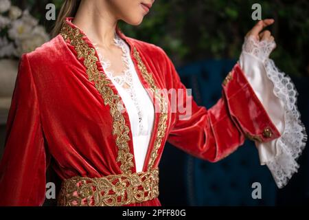 Une fille dans une tenue kazakh nationale rouge sur Nauryz. Banque D'Images