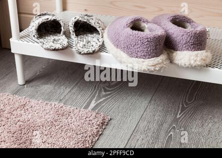 Les pantoufles en laine se tiennent sur une étagère blanche, photo de gros plan Banque D'Images