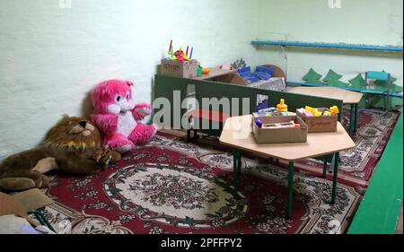 CHYHYRYN, UKRAINE - 15 MARS 2023 - des bureaux et des jouets sont laissés sur les tapis dans le refuge à la bombe mis en place par les élèves et les enseignants de Chyhyryn Lyceum Banque D'Images