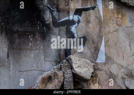 Gros plan de l'artiste peint une jeune fille gymnaste dans une main à l'envers, comme s'il s'était penché sur les ruines de la maison. L'auteur a signé son travail comme suit Banque D'Images