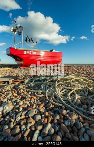 Bateau de pêche rouge sur la plage de Worthing à West Sussex, Angleterre. Banque D'Images