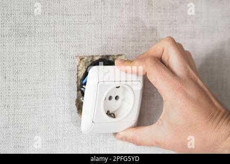 Dangereux mauvais, prise cassée, prise dans la salle de bains, tomber du mur. Installation d'un point de vente dans l'ancien appartement. Mauvais fil électrique, réparer.terrible faire-il vous Banque D'Images