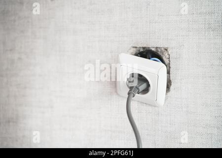 Dangereux mauvais, prise cassée, prise dans la salle de bains, tomber du mur. Installation d'un point de vente dans l'ancien appartement. Mauvais fil électrique, réparer.terrible faire-il vous Banque D'Images