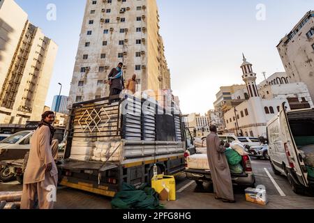 Vue d'hommes locaux chargeant des balles achetées de produits textiles sur un camion, à côté du souk à Al-Balad, Jeddah, KSA, Arabie Saoudite Banque D'Images