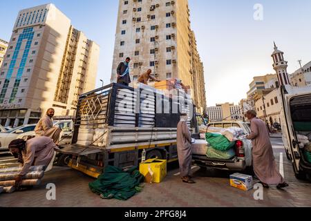 Vue d'hommes locaux chargeant des balles achetées de produits textiles sur un camion, à côté du souk à Al-Balad, Jeddah, KSA, Arabie Saoudite Banque D'Images