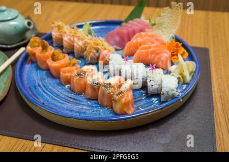 Mélange de différents sushis japonais sur une élégante assiette bleue. Banque D'Images