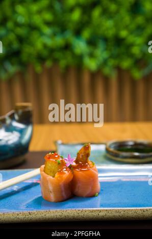Mélange de différents sushis japonais sur une élégante assiette bleue. Banque D'Images