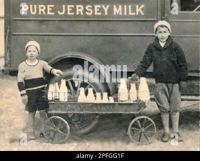 Vieux camion de lait début 1900s, garçons vendant du lait, bouteilles de verre, chariot, camion de lait à l'ancienne début 1900s Banque D'Images