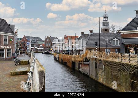 Des filets de pêche sont suspendus pour sécher sur le quai de la ville de Lemmer en Frise. Banque D'Images