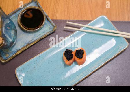 Mélange de différents sushis japonais sur une élégante assiette bleue. Banque D'Images