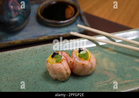Mélange de différents sushis japonais sur une élégante assiette bleue. Banque D'Images