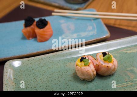 Mélange de différents sushis japonais sur une élégante assiette bleue. Banque D'Images