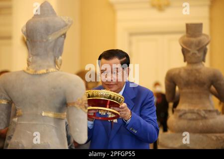 Phnom Penh, Cambodge. 17th mars 2023. Le Premier ministre cambodgien Samdech Techo Hun Sen adore une ancienne statue khmère au Palais de la paix de Phnom Penh, au Cambodge, au 17 mars 2023. Vendredi, le Cambodge a célébré le retour de centaines d'antiquités khmères plées et de bijoux anciens à la nation d'Asie du Sud-est de l'étranger. Crédit : Ly Lay/Xinhua/Alay Live News Banque D'Images