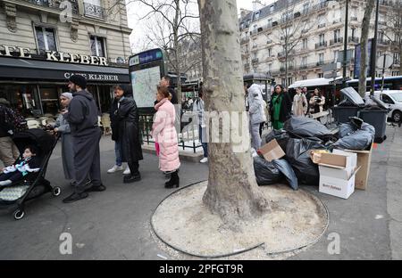 Paris, France. 17th mars 2023. Les gens attendent devant un restaurant à la place du Trocadéro, tandis que des ordures sont vues dans la rue à Paris, France, 17 mars 2023. Il est probable que les ordures continuent de s'accumuler dans la capitale, puisque les collecteurs de déchets et les nettoyeurs de rue seront en grève jusqu'à 20 mars. Credit: Gao Jing/Xinhua/Alamy Live News Banque D'Images