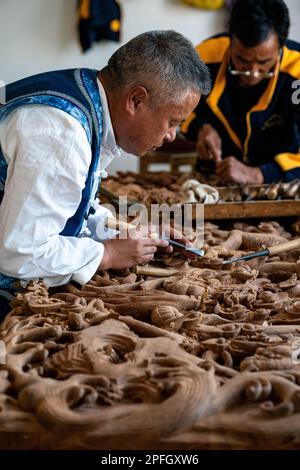 (230317) -- JIANCHUAN, 17 mars 2023 (Xinhua) -- Duan Sixing (L) fait un travail de sculpture sur bois dans son studio dans le comté de Jianchuan, préfecture autonome de Dali Bai, dans la province du Yunnan, au sud-ouest de la Chine, à 11 mars 2023. Le comté de Jianchuan, situé dans la préfecture autonome de Dali Bai, dans la province du Yunnan, dans le sud-ouest de la Chine, a une longue histoire de sculpture sur bois datant des dynasties Tang (618-907) et Song (960-1279). Les compétences de sculpture se sont progressivement développées d'un relief d'une couche jusqu'à un relief de creux de sept couches, et sont maintenant appliquées à la fabrication de pièces d'architecture, de meubles en bois, de peintures murales et de touris Banque D'Images