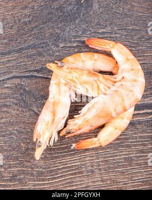 Crevettes fraîches entières cuites sur fond de bois avec espace de copie, plat. Concept d'alimentation saine Banque D'Images