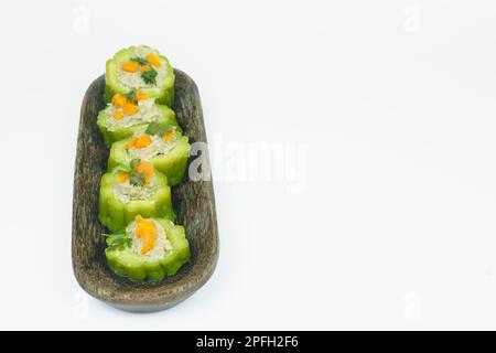 Pâté ou gourde amer farci de viande de poulet hachée servie sur l'assiette en bois. Isolé sur fond blanc. Banque D'Images