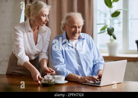 Couple, homme et femme à la retraite, charmant et mature, regardant sur un ordinateur portable, choisissant de voyager, faisant des achats en ligne, payant des factures Banque D'Images