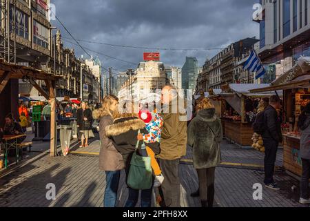 Vue vers la place de Brouckère à Bruxelles en soirée d'hiver, faible soleil et ciel nuageux. Groupe de personnes. Banque D'Images