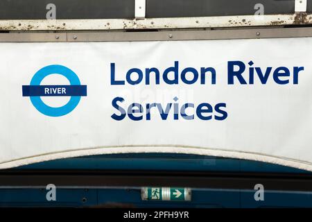 Logo London River Services bannière d'information publicitaire au Festival Pier, un arrêt de bateau où les passagers embarquent et débarquent des bateaux à aubes et du bateau d'excursion sur la Tamise. Londres. ROYAUME-UNI. (133) Banque D'Images