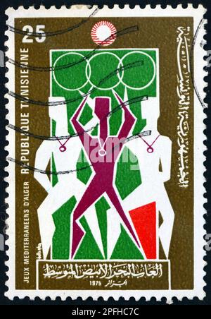 TUNISIE - VERS 2975: Un timbre imprimé en Tunisie montre les vainqueurs, Jeux méditerranéens de 7th, Alger, vers 1975 Banque D'Images