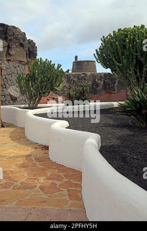 Torre Del Aguila - Castillo de Las Coloradas prise de Marina Rubicon avec jardin ornemental en premier plan, Playa Blanca, Lanzarote, Espagne, 2023. cym Banque D'Images
