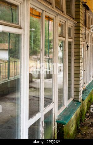 Une vue intéressante des vieilles fenêtres dans un bâtiment oublié dans le style des années 80, urbex. Banque D'Images
