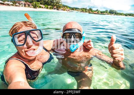 Couple senior prenant un selfie heureux à l'excursion en mer tropicale avec caméra à eau - excursion en bateau avec plongée en apnée concept dans des scénarios exotiques - vie active à la retraite Banque D'Images