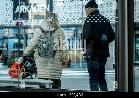 Stavanger, Norvège, 10 mars 2023, couple d'âge moyen Homme et femme attendant Un bus Transpot public transportant des Shopping Banque D'Images