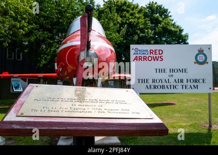 Royal Air Force Red Arrows affiche l'avion à réaction de l'équipe BAe Hawk T1 exposé à RAF Scampton. Hangar et panneau. Mémorial aux pilotes tués Banque D'Images