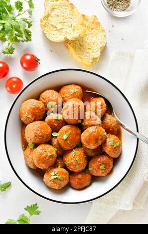 Boulettes de viande avec sauce tomate dans un bol sur fond de pierre blanche.Vue de dessus, plan d'appartement Banque D'Images