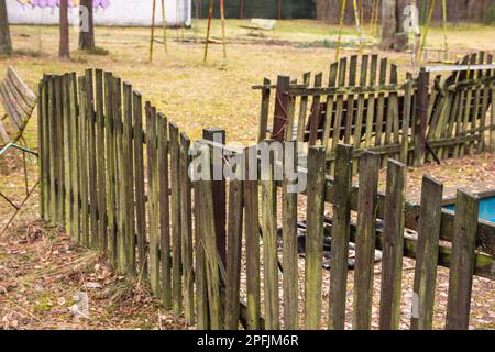 Une vieille clôture de mousse, un jour d'automne parmi les vieux bâtiments. Banque D'Images