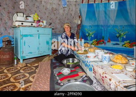 La femme kazakh nomade prépare la table pour les invités dans une yourte, Asie centrale, Parc national d'Ile-Alatau, plateau d'Assy, Almaty, Kazakhstan Banque D'Images