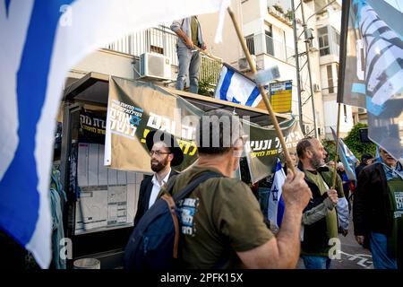 Bnei Brak, Israël. 16th mars 2023. Les résidents ultra-orthodoxes de Bnei Brak marchent à côté d'une protestation des soldats de la réserve israélienne contre la réforme judiciaire. Les soldats ont ouvert un « centre de recrutement » au service militaire des FDI dans le cadre d’un acte de protestation contre la révision judiciaire de la ville ultra-orthodoxe de Bnei Brak. Crédit : SOPA Images Limited/Alamy Live News Banque D'Images