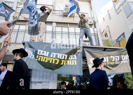 Bnei Brak, Israël. 16th mars 2023. Les résidents ultra-orthodoxes de Bnei Brak marchent à côté d'une protestation des soldats de la réserve israélienne contre la réforme judiciaire. Les soldats ont ouvert un « centre de recrutement » au service militaire des FDI dans le cadre d’un acte de protestation contre la révision judiciaire de la ville ultra-orthodoxe de Bnei Brak. Crédit : SOPA Images Limited/Alamy Live News Banque D'Images