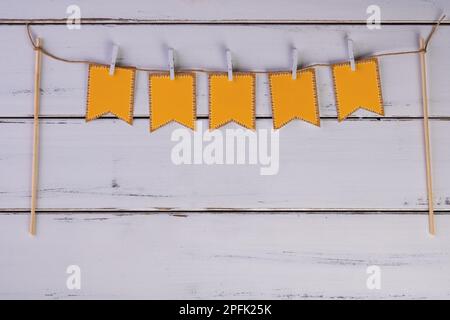 corde à linge avec drapeaux de fête sur une table en bois blanc. Banque D'Images