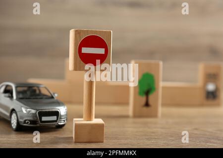 Panneau de signalisation pas d'entrée et voiture-jouet sur une table en bois. Réussite à l'examen du permis de conduire Banque D'Images